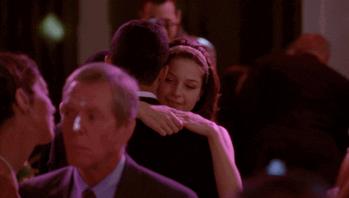 a man and woman are hugging in a crowded room