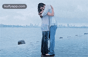 a man and a woman hugging each other in the water .