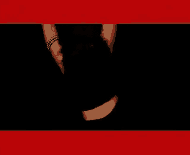 a woman in a black crop top and black pants is dancing in a dark room .