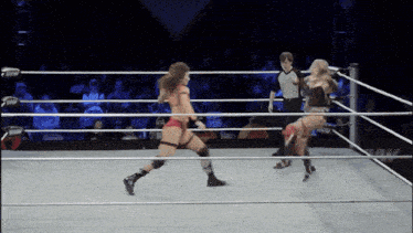 two women are wrestling in a ring with a referee and the word raw on the side