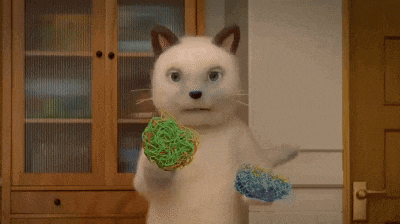 a cat is holding a ball of noodles in its paws