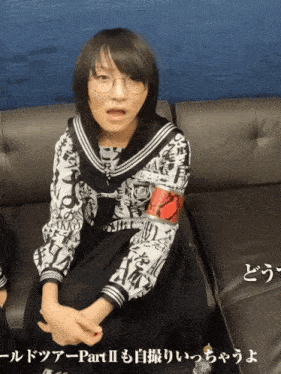 a girl wearing glasses is sitting on a couch with part ii written on it