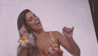 a woman in a bikini is laughing and holding her breasts .