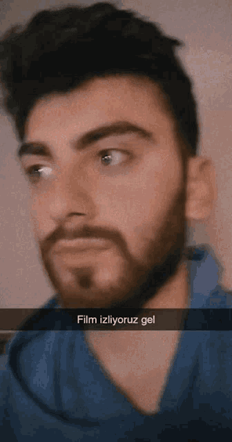 a man with a beard and a caption that says film izliyoruz gel on it