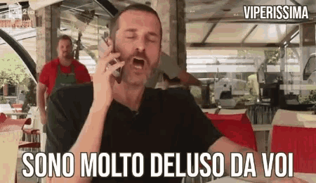 a man is talking on a cell phone with the words sono molto deluso da voi on the bottom