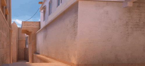 a man in a blue shirt is jumping in the air in front of a building with a sign that says ' ambulance '