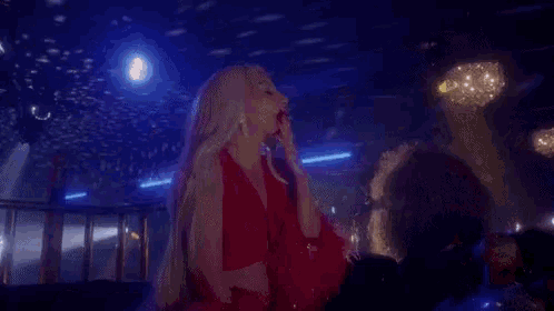 a woman in a red dress is dancing with a man in a club .