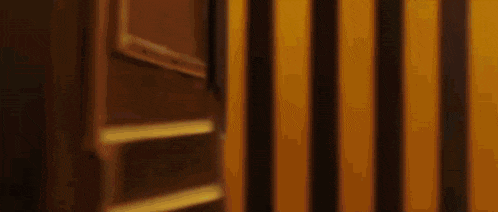a close up of a yellow and black striped wall with a door in the background .