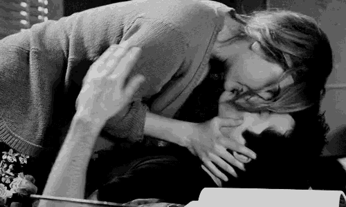 a black and white photo of a couple kissing