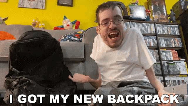 a man sitting on a couch with the words i got my new backpack