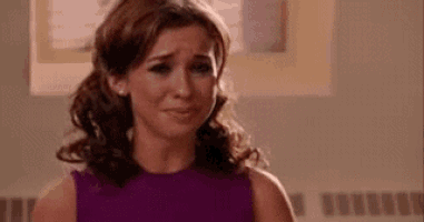 a woman in a purple dress is crying and looking at the camera .