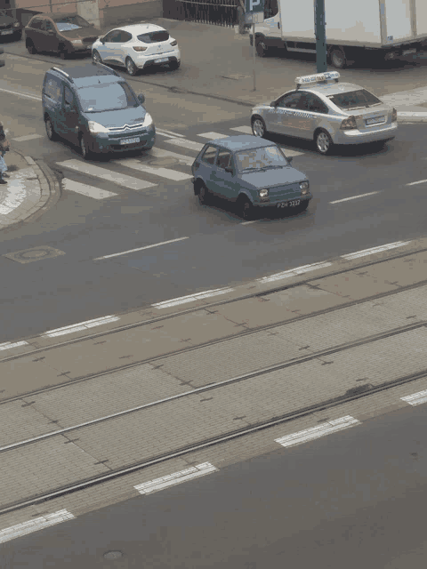 a blue car with a license plate that says pdn 6542 drives down a street