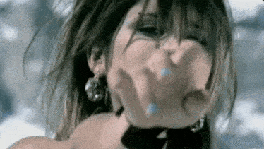 a close up of a woman 's face with a blurred background .