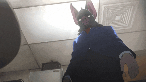a man in a suit and tie with a bat mask on