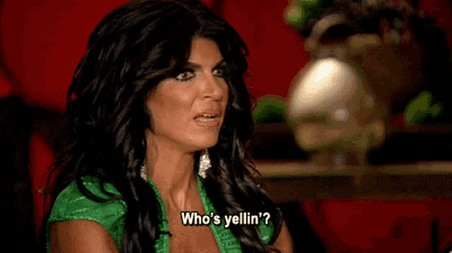 a woman in a green dress says who 's yellin '