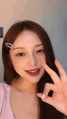 a woman with a clip in her hair is giving a peace sign