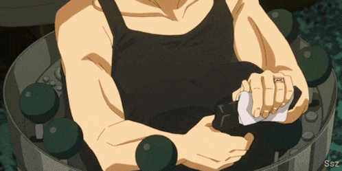 a man with a ring on his finger is sitting in a circle of green dumbbells
