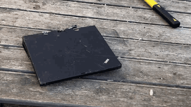 a thinkpad laptop is laying on a wooden surface