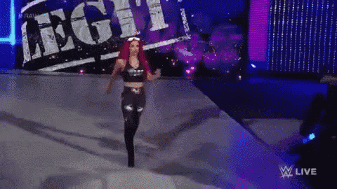 a woman with red hair is walking on a stage in front of a sign that says legi .