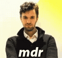 a man with a beard is wearing a black sweater that says mdr on it .