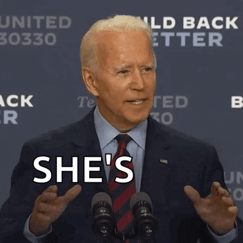 a man in a suit and tie says she 's at a podium