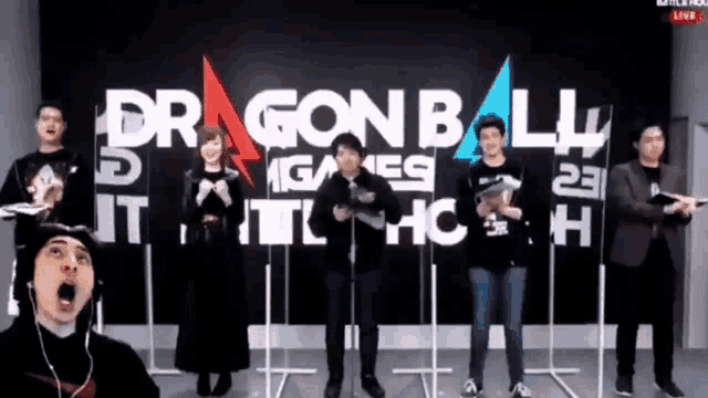a group of people are standing in front of a dragon ball sign