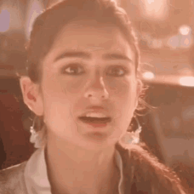 a close up of a woman 's face with a surprised expression on her face .