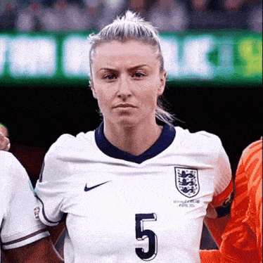 a woman wearing a white jersey with the number 5