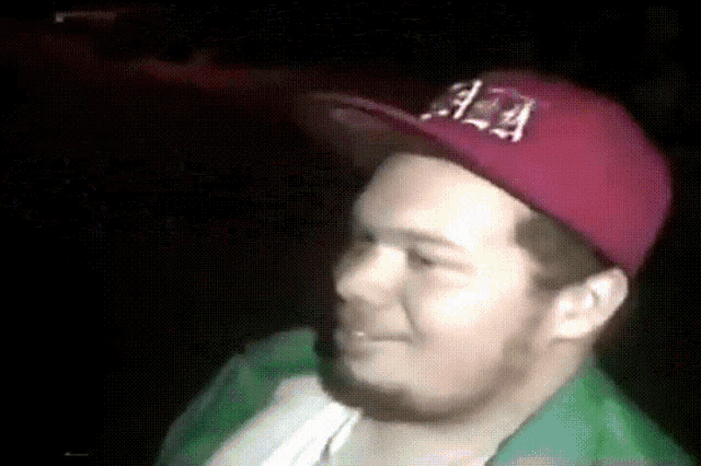 a man wearing a red hat with the letter a on it is smiling