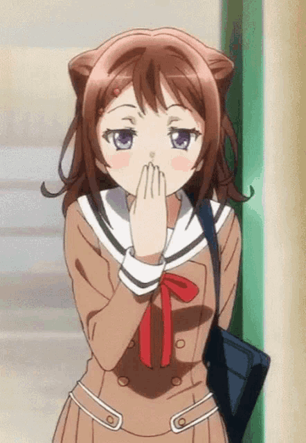 a girl with cat ears is covering her mouth with her hands .