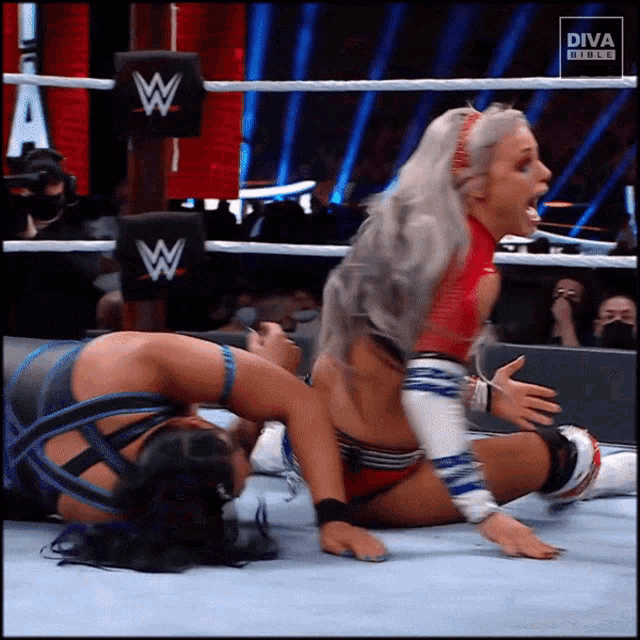 two women are wrestling in a wrestling ring with diva on the bottom left