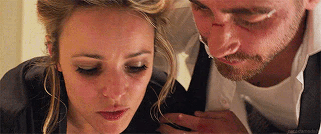 a man and a woman are looking at each other . the man has a bandage on his face and the woman is crying .