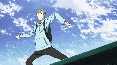 a man in a blue hoodie is jumping over a wall