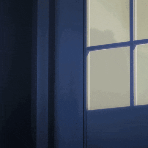 a dark room with a blue door and a white window