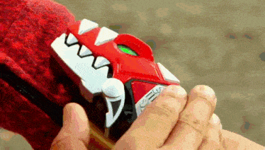 a person is holding a toy that looks like a dinosaur with a green light on it .