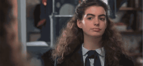 a woman in a suit and tie is looking at the camera