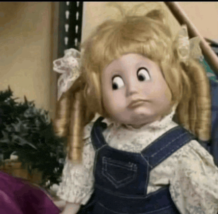 a doll with blonde hair and overalls looks sad