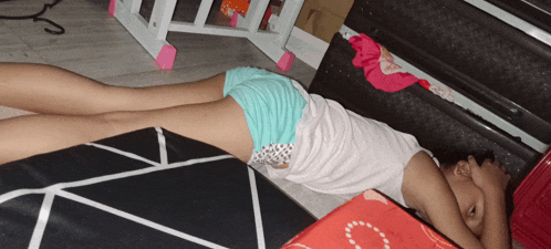 a young girl is laying on the floor with her head on her hand