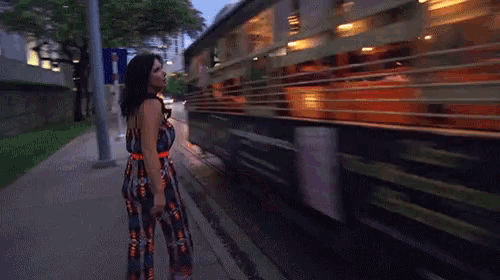 a woman is standing in front of a trolley that has the word trolley on the side