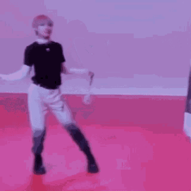 a man is dancing on a pink floor .