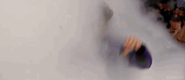 a person is standing in a room filled with smoke and holding a bottle .