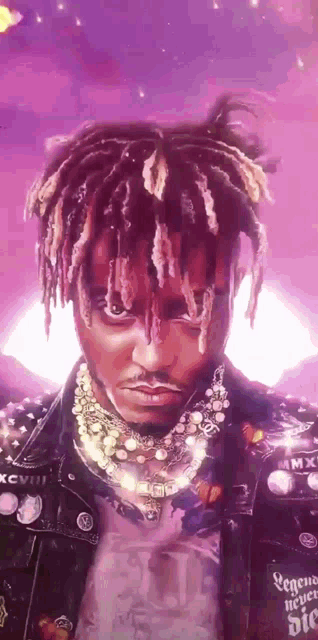 a man with dreadlocks and a purple background is wearing a leather jacket .