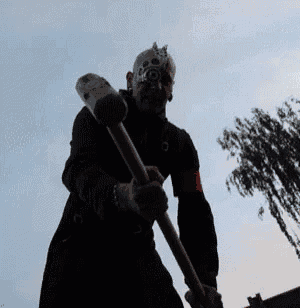 a man wearing a gas mask is holding a hammer