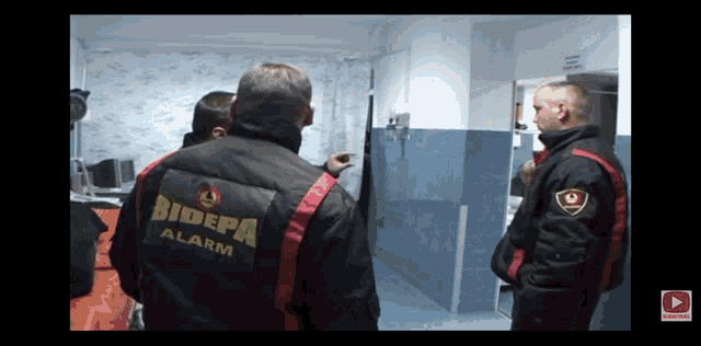 a man in a bidepa alarm jacket stands in a room