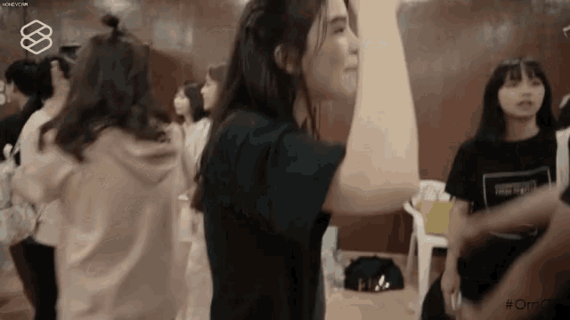 a group of young women are standing in a room dancing .