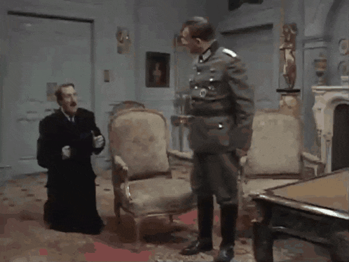 a man in a military uniform talks to another man in a black robe
