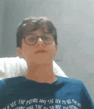 a young boy wearing glasses and a blue shirt that says i see the future save the sea to see the future
