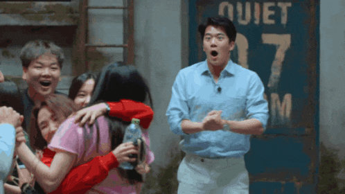 a group of people are hugging in front of a sign that says quiet 7 am