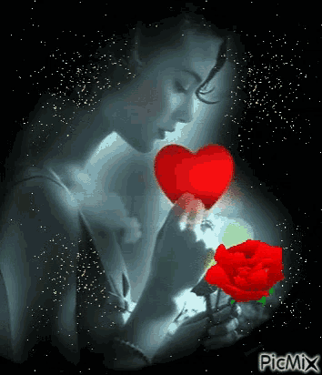 a woman is holding a red rose and a red heart in her hands