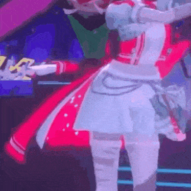 a woman in a red and white dress is standing on a stage in a dark room .